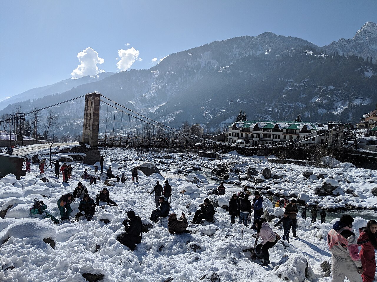 Snow beside a suspension bridge in Manali