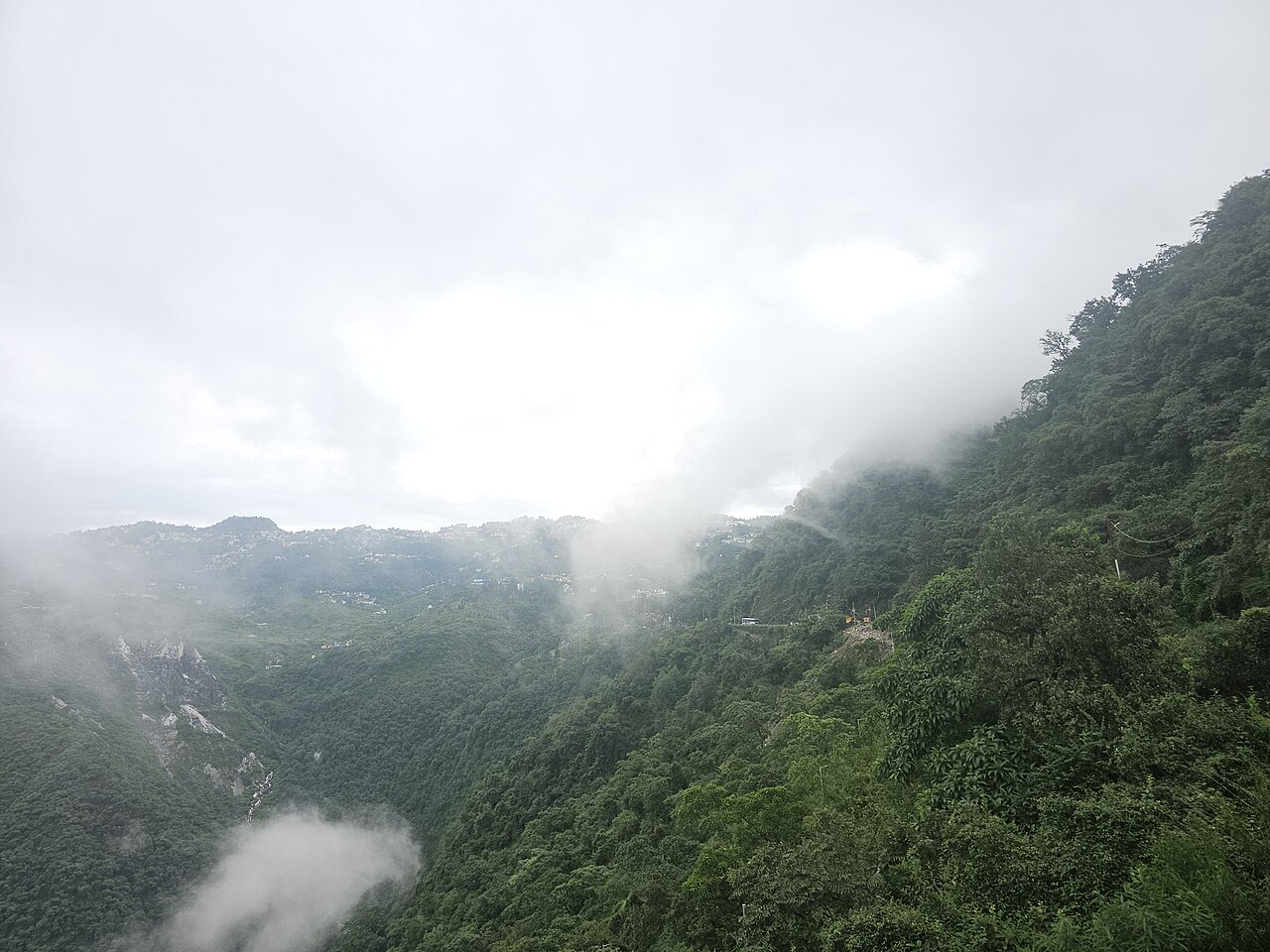 Clouds over wooded hills and buildings in Mussoorie