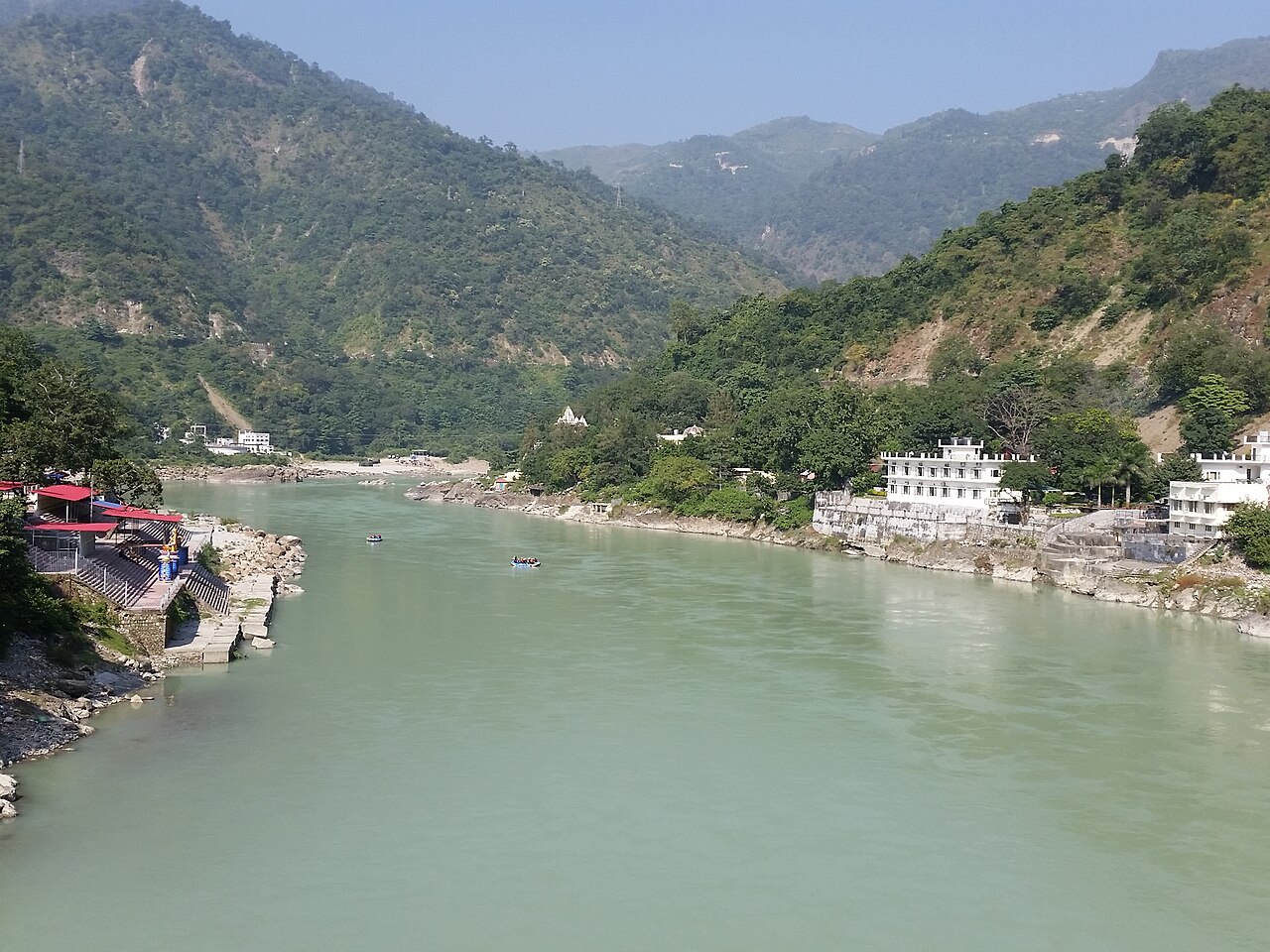 The Ganga flowing between hills and buildings in Rishikesh